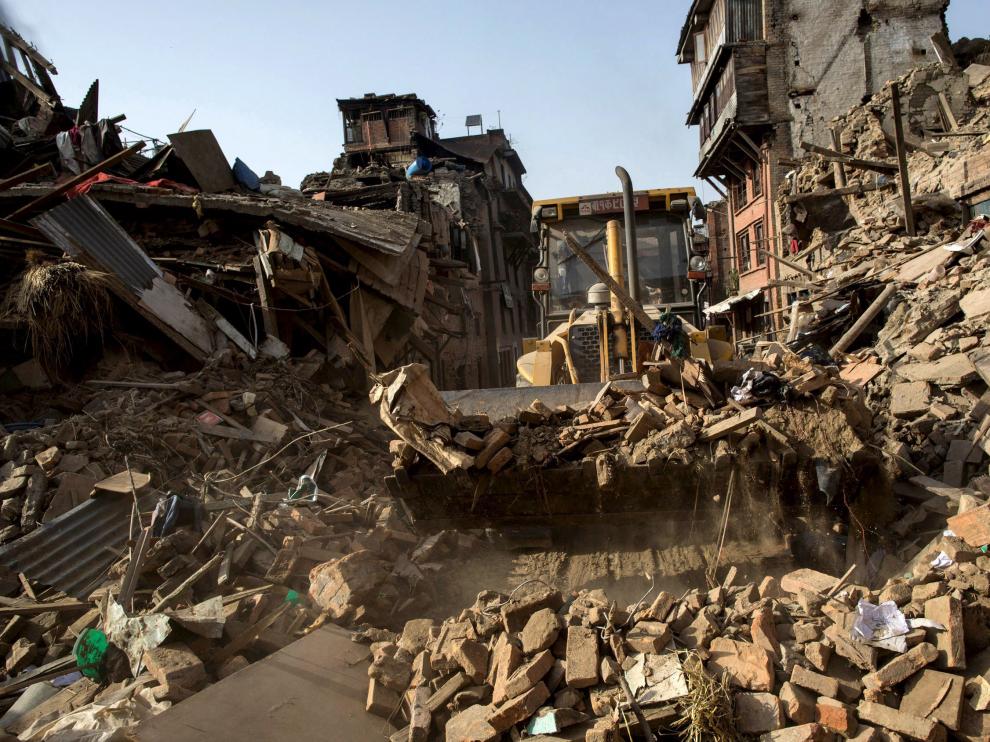 Una excavadora retira escombros en una localidad de Nepal