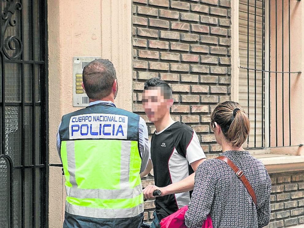 Dos policías hablan con un primo del chico tiroteado.