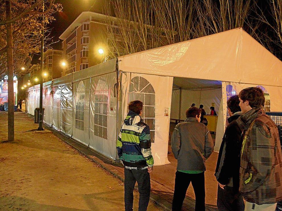 Menores ante la puerta de la carpa instalada en la Encarnación donde anoche se celebró la verbena.