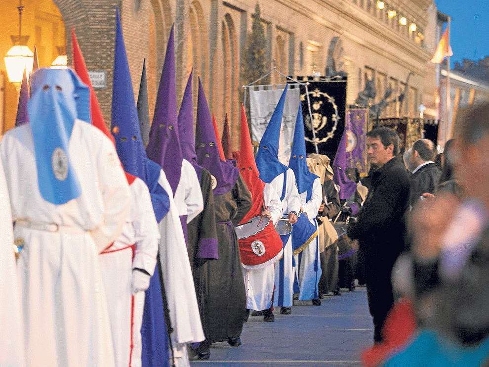 La procesión, con representantes de todas las cofradías, poco antes de alcanzar la bandeja de la plaza del Pilar.