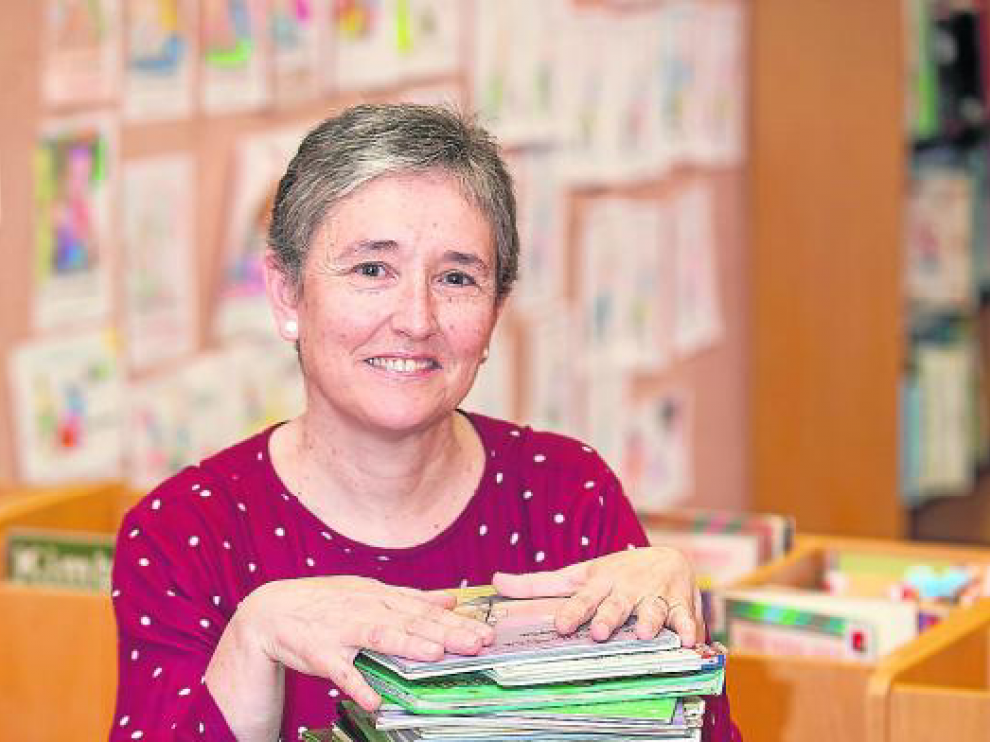 Carmen Carramiñana, feliz, rodeada de libros infantiles.