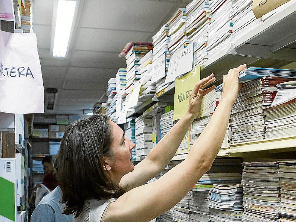 Foto de archivo de una librería ordenando libros de texto.