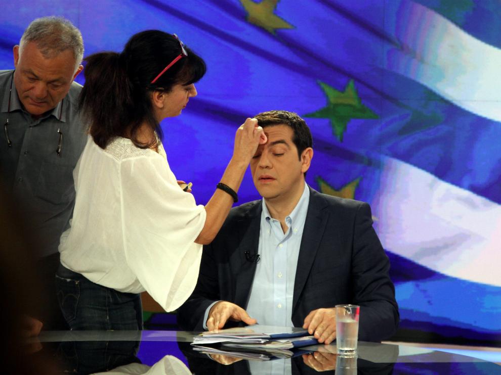 Una empleada de la televisión pública griega maquilla a Tsipras antes de la entrevista de la noche del lunes.