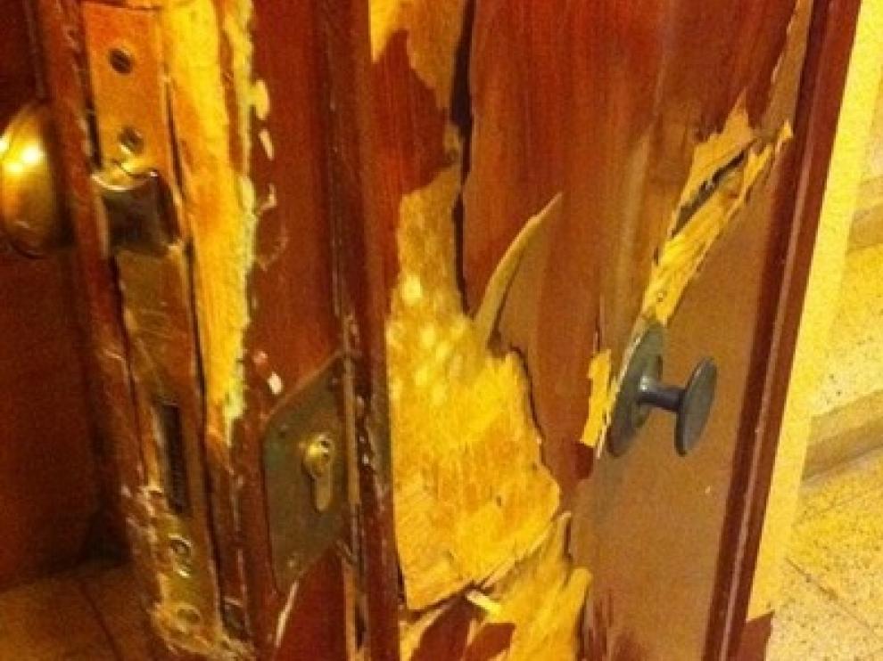 Así quedó la puerta de una casa desvalijada en Zaragoza