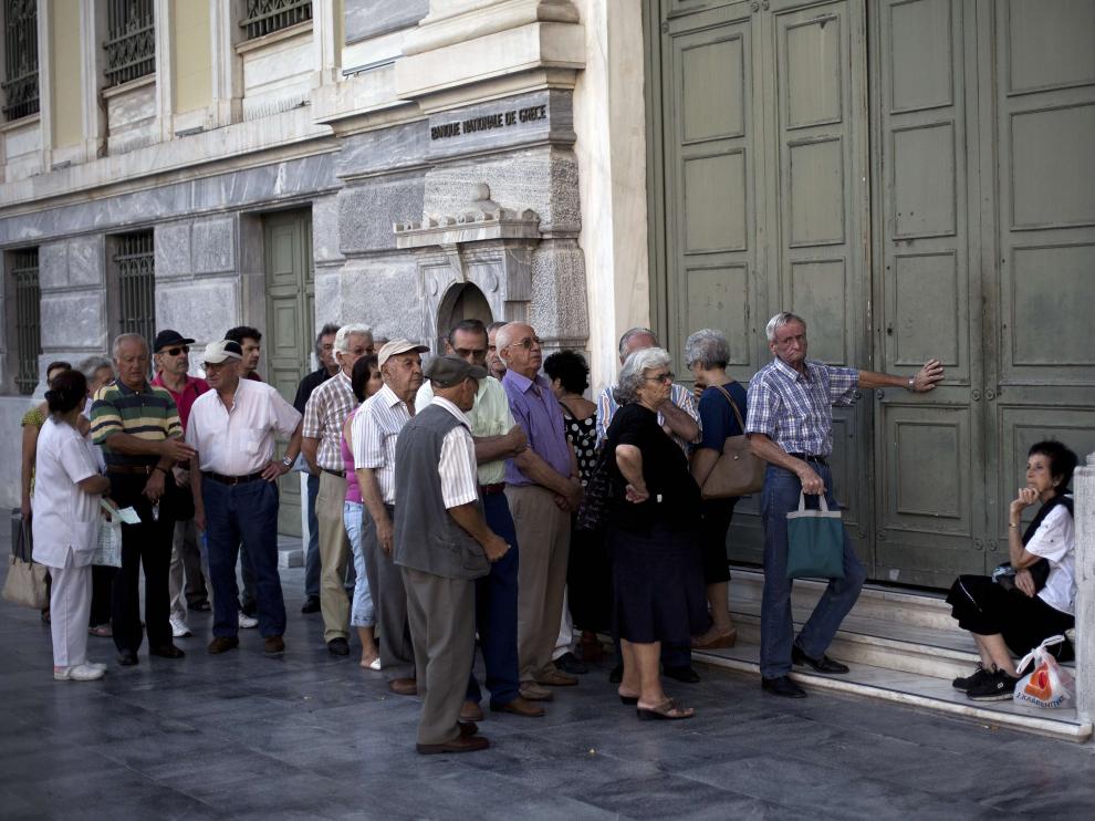 Un grupo de jubilados espera en la puerta del Banco Nacional de Gracia. (Archivo)
