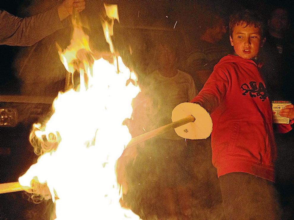 El ritual del fuego. Los vecinos suben a la montaña con antorchas confeccionadas con ramas. Luego bajan haciendo girar las fallas sobre sus cabezas y una vez en el pueblo se enciende una hoguera. En la imagen, de archivo, un niño prende su tea en Laspaúle