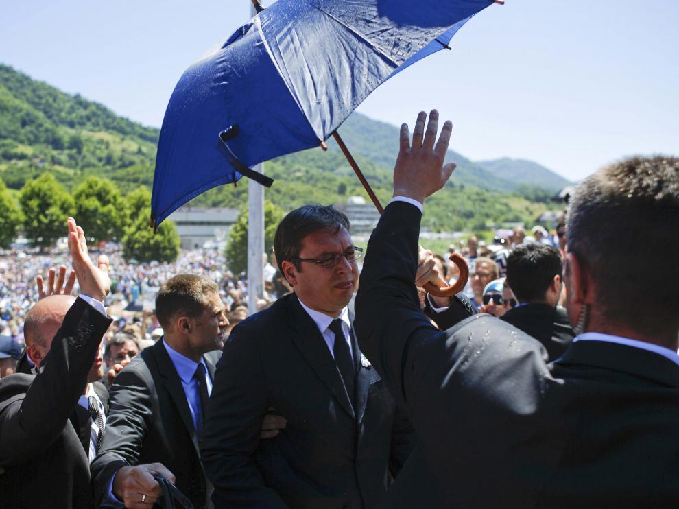 Los guardaespaldas protegen al primer ministro serbio de las pedradas con un paragüas.