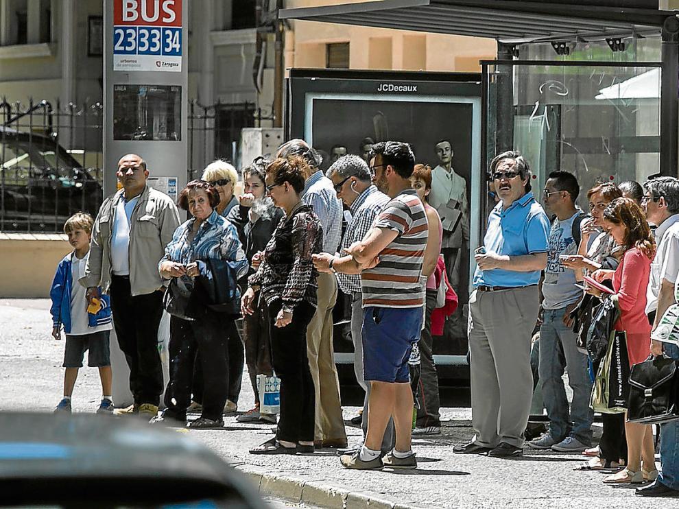 Usuarios bajo una marquesina del paseo de Sagasta, donde se concentran varias de las líneas con más demanda de la ciudad.