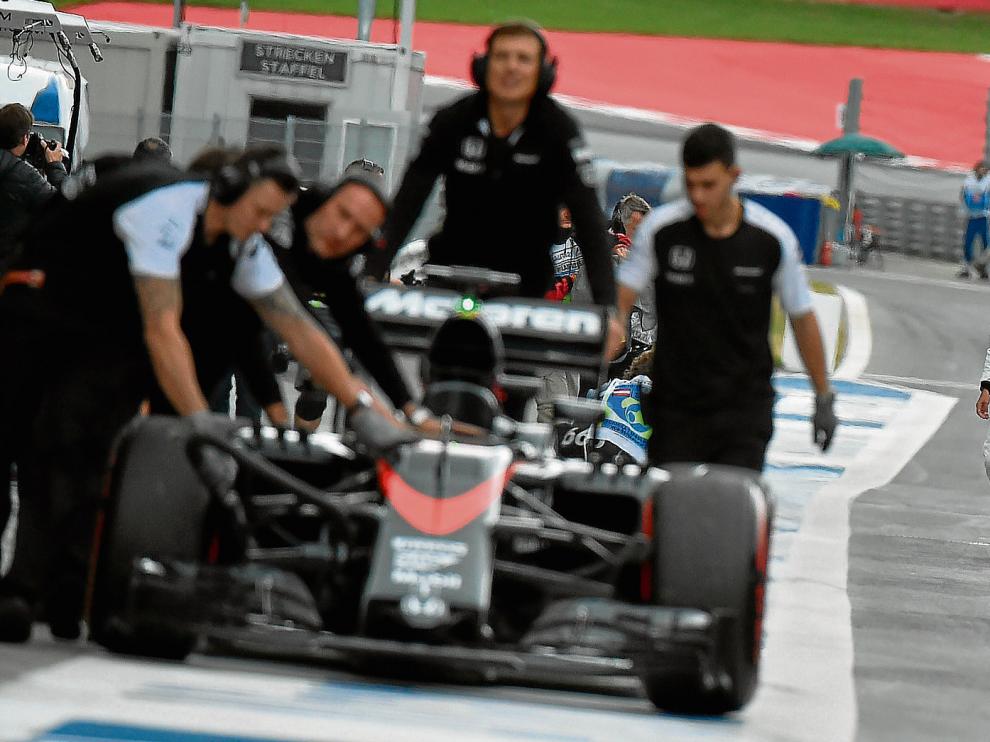Fernando Alonso, al fondo, observa cómo retiran su monoplaza, ayer en el circuito Red Bull Ring.