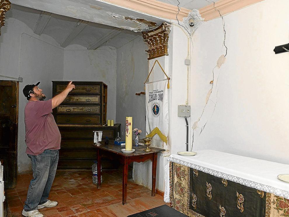 Un vecino muestra las filtraciones y las grietas que recorren la sacristía de la iglesia.