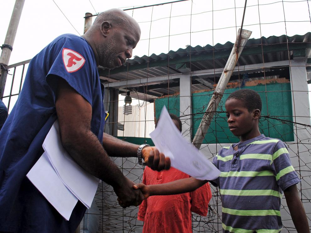 Un niño recibe en Liberia el certificado que acredita que está curado de ébola.