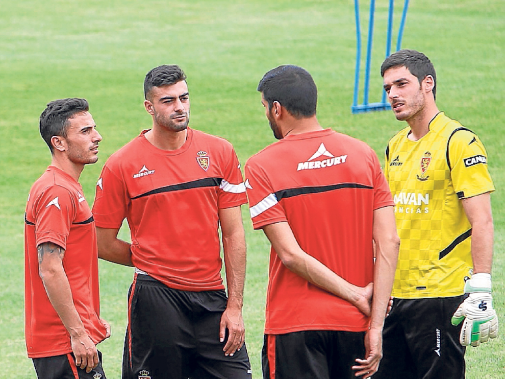 Fernández (izda.), Álamo (de espaldas) y Alcolea (dcha.), tres de los que deben abandonar el Real Zaragoza por cuestiones económicas, charlan con Rico durante un entrenamiento la semana pasada.
