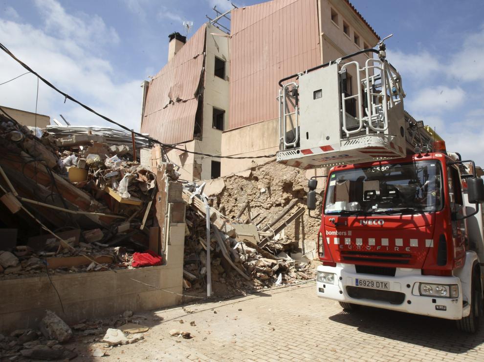 Un camión de Bomberos, junto al edificio derruido