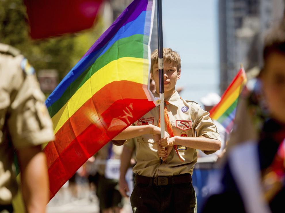 Un boy scout desfilando con la bandera homosexual.