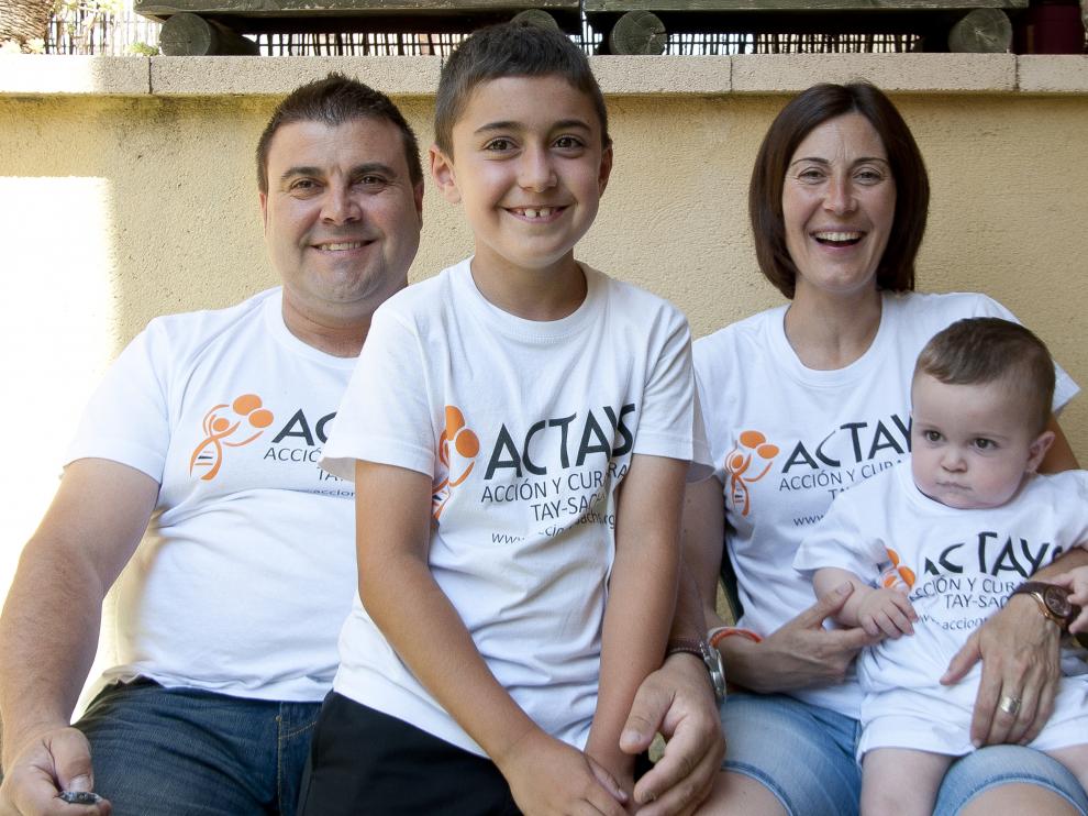 El pequeño Hugo (d), de 16 meses, junto a sus padres y su hermano vestidos con las camisetas de la asociación Actays.