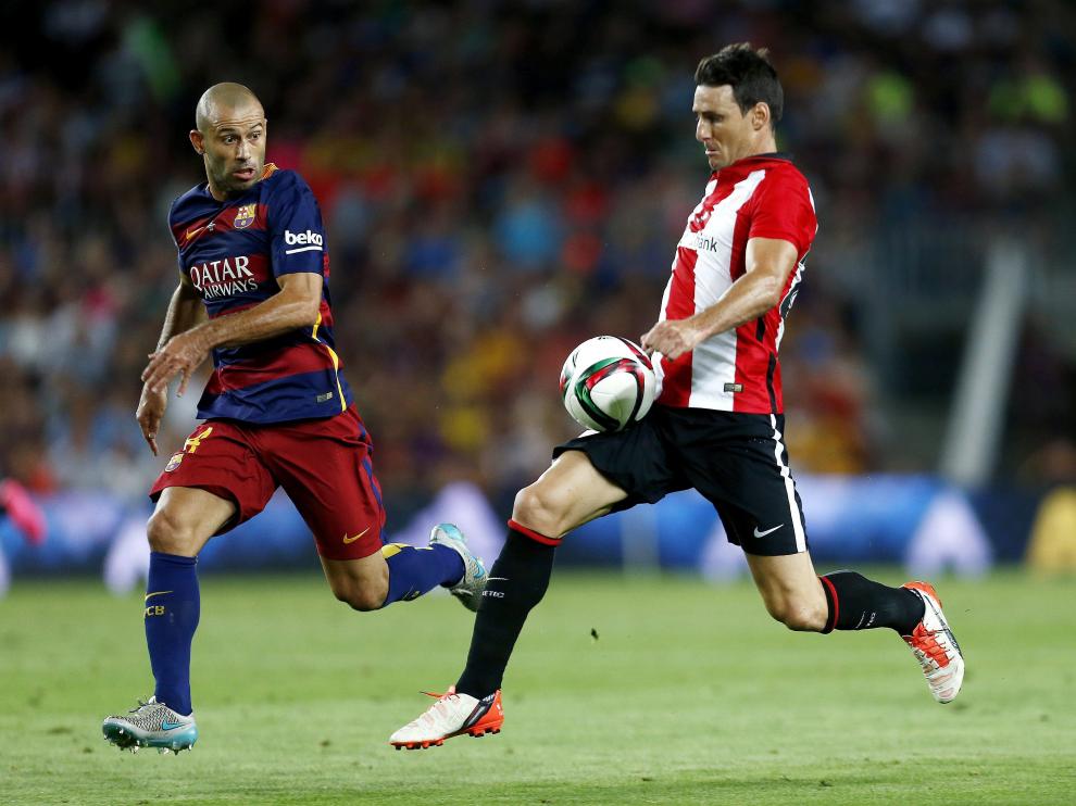El defensa argentino del FC Barcelona Javier Mascherano (i) persigue al delantero del Athletic Club Aritz Aduriz.