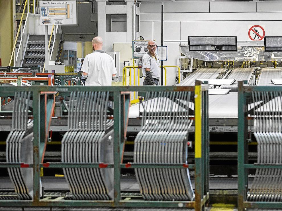 Imagen de algunos operarios trabajando en las naves de la factoría zaragozana de General Motors este pasado mes de mayo.