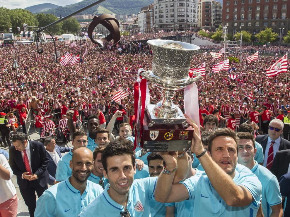 El capitán Carlos Gurpegui (c), sujeta el trofeo junto al resto de los jugadores del Athletic ante miles de personas.