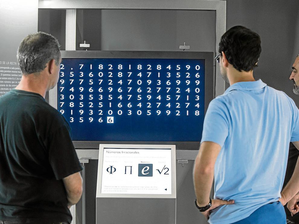 Unos visitantes observan en una pantalla el desarrollo irregular del número 'e', de la familia de los irracionales.