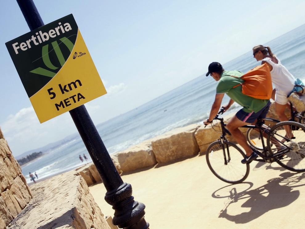 Dos turistas circulan por el paseo marítimo de Puerto Banús por donde este sábado pasará la Vuelta.