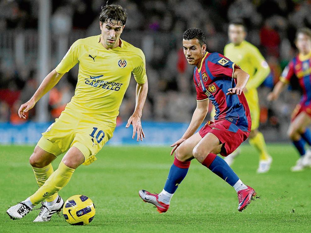 El aragonés Cani protege el balón ante Pedro, durante un partido ante el Barcelona.