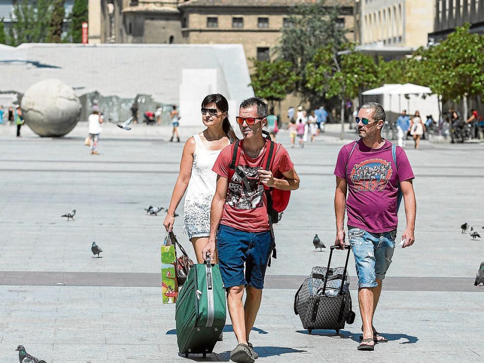 Un grupo de turistas atraviesa la plaza del Pilar, ayer por la mañana.