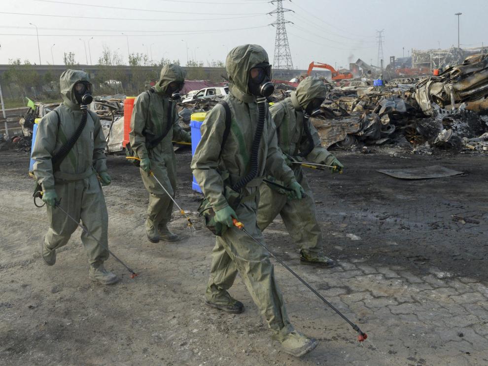 Varios soldados del Ejército de la Liberación del Pueblo de China trabajan para neutralizar los residuos de cianuro de sodio en Tianjin.