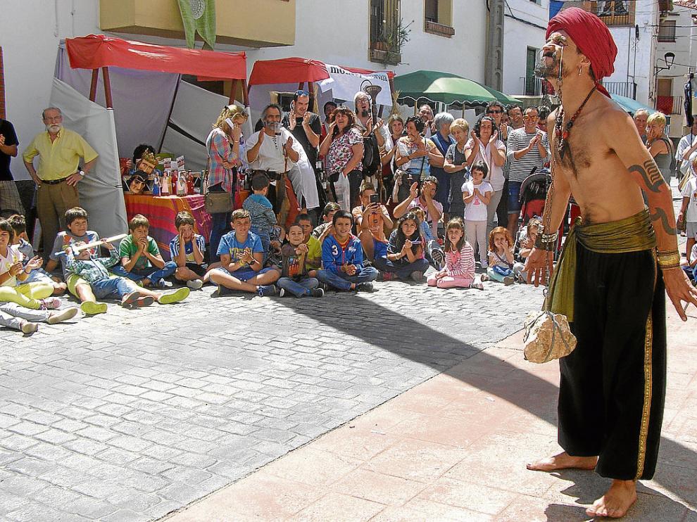 Un faquir levanta una piedra colgada de los ojos ante las asombradas miradas de los niños.
