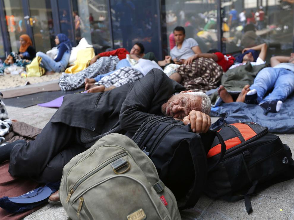 Varios inmigrantes descansan junto a una estación de tren Budapest