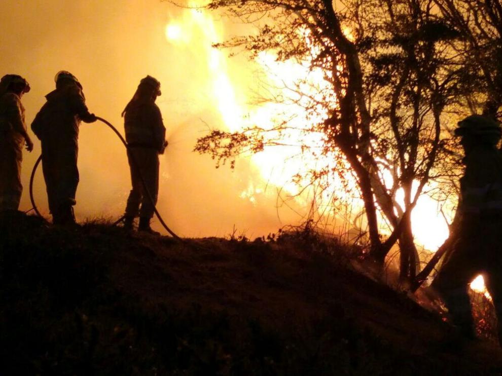 Varios bomberos intentando controlar el incendio declarado en Valderredible.