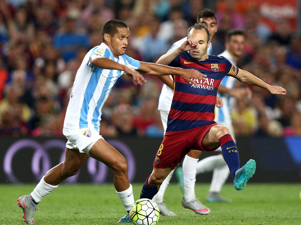 Iniesta lucha el balón con Juanpi, durante el partido de la segunda jornada del Campeonato de Liga.