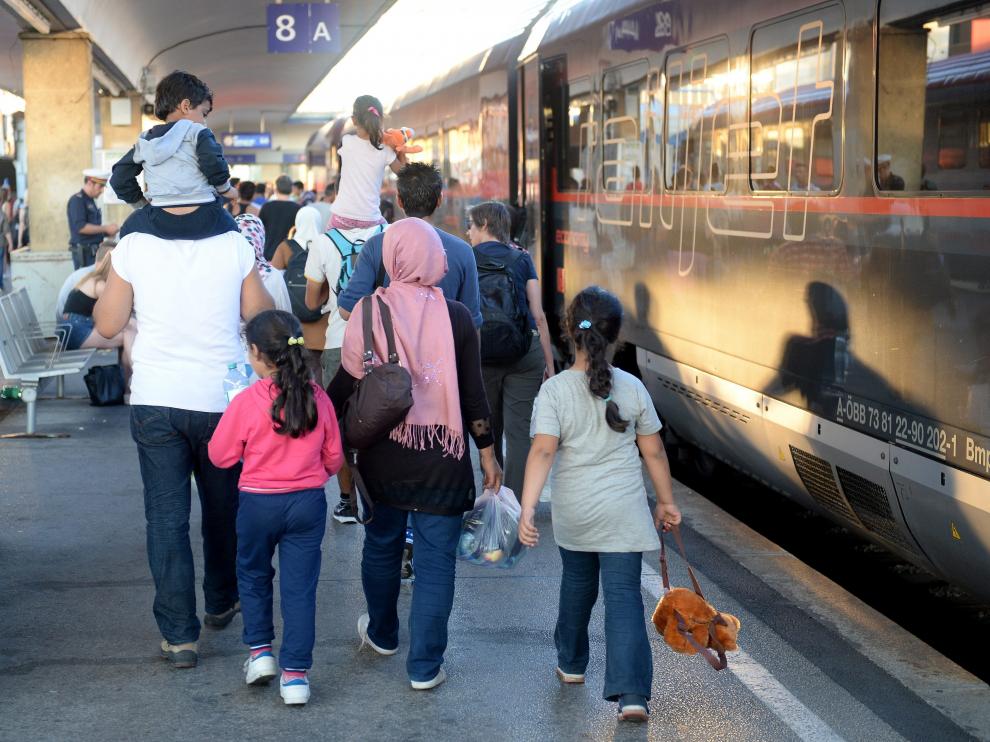 Varios refugiados procedentes de Hungría se suben a un tren con destino a Alemania.