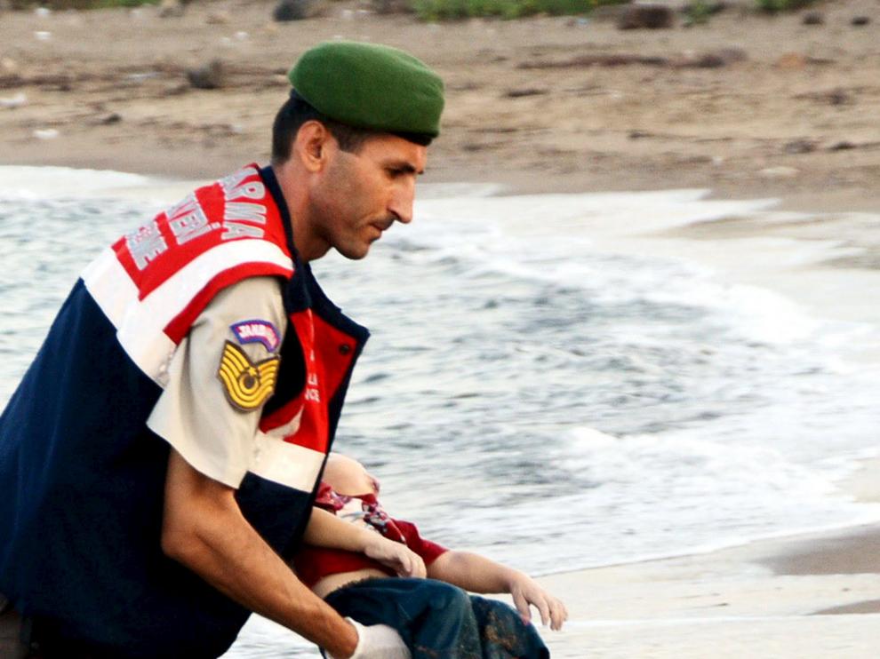 Un gendarme toma en sus brazos el cuerpo sin vida del niño kurdo sirio Aylan Kurdi, aparecido en la playa turca de Bodrum este 2 de septiembre.