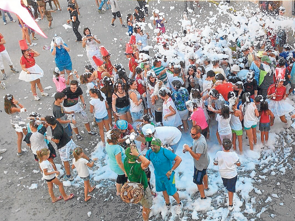 Los vecinos pudieron disfrutar de una fiesta de la espuma tras la cabalgata de carrozas.