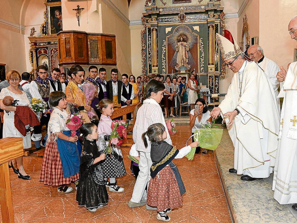 El cardenal Santos Abril recibe las ofrendas de un grupo de niños en la iglesia de Alfambra.