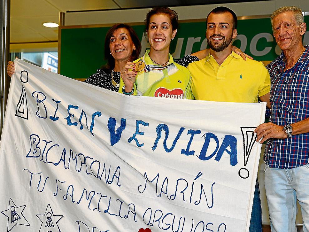 Carolina Marín, recibida ayer por sus padres y su pareja en el aeropuerto de Madrid.