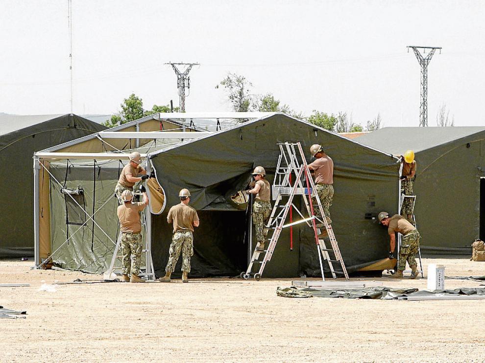 Miembros del grupo de apoyo de la OTAN montan las tiendas del cuartel general en la base.
