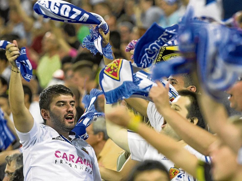 Los seguidores del Real Zaragoza sueltan sus bufandas al viento para celebrar el triunfo.