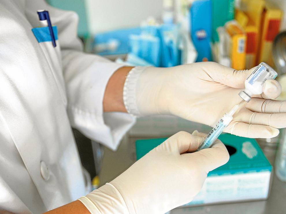 Una profesional sanitaria prepara una vacuna para su posterior inyección.