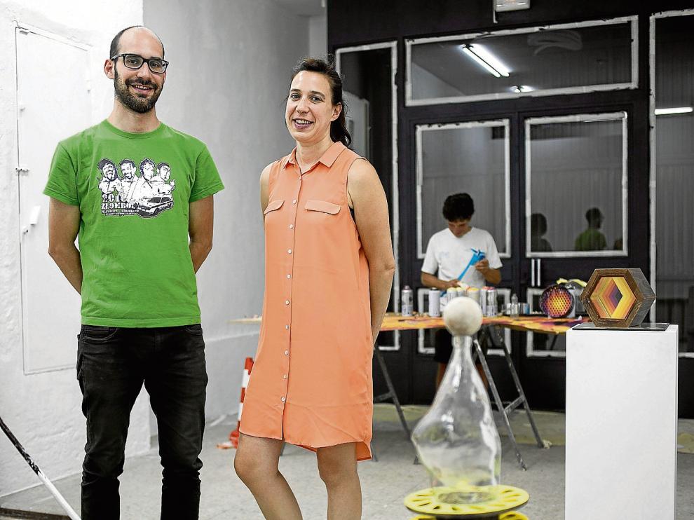 Los hermanos José Antonio y Patricia Rodrigo, responsables de la galería Antonia Puyó. Atrás, el artista E1000, en plena faena.