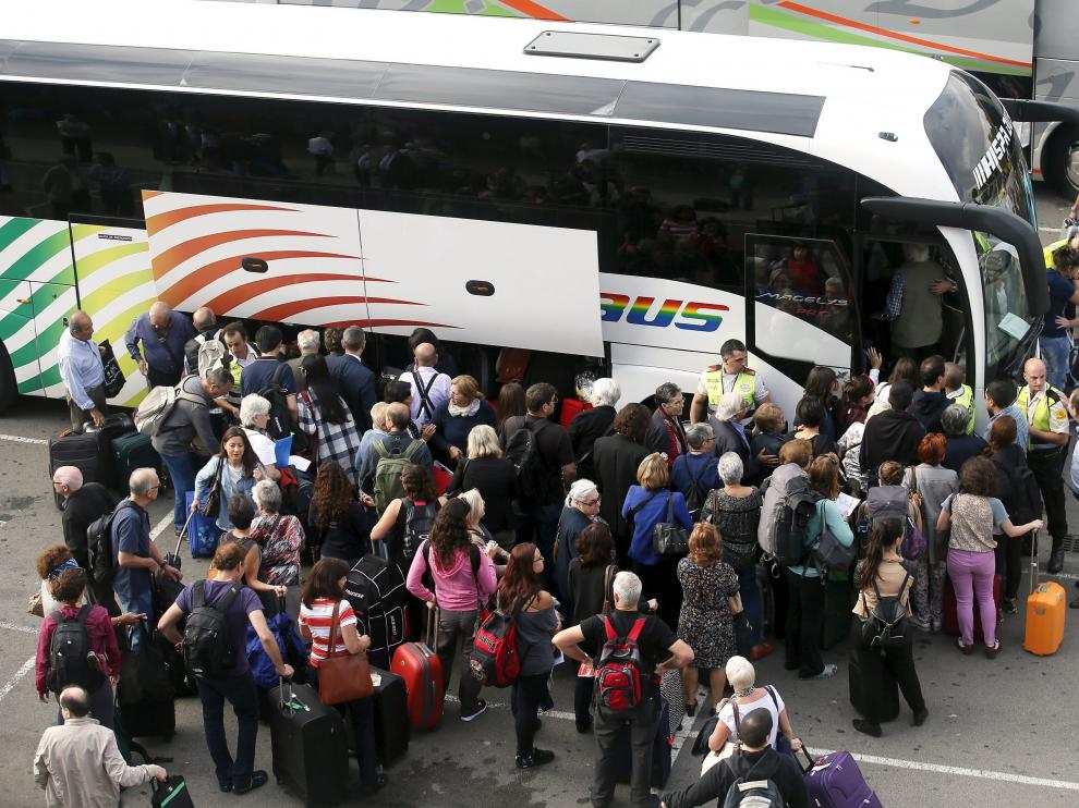 Varios pasajeros toman un bus lanzadera a causa de la suspensión de la línea ferroviaria.