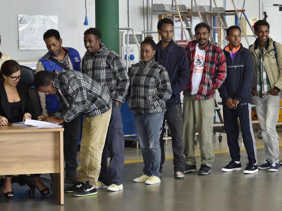 Un grupo de eritreos guardan fila antes de partir de Italia hacia Suecia.
