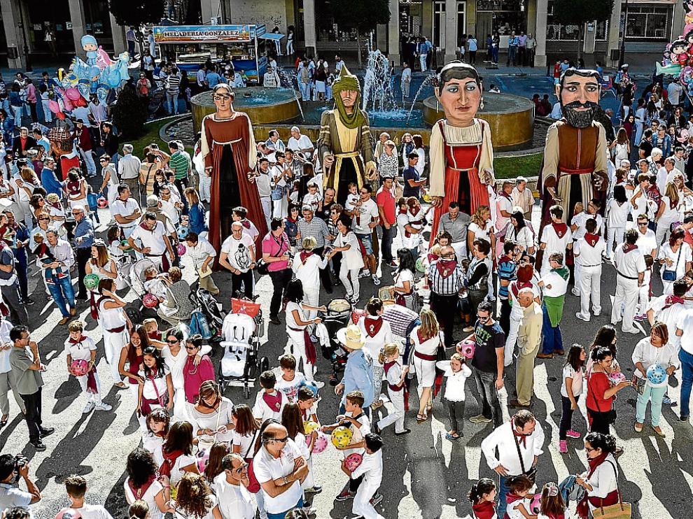 La comparsa de gigantes y cabezudos siguió al chupinazo en el primer día festivo en Tauste.