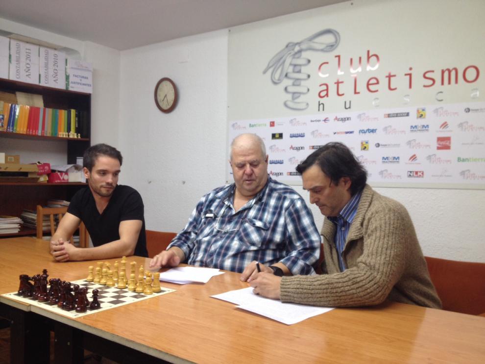 momento de la firma del convenio. De izquierda a derecha, Daniel Lafarga, presidente de la Asociación de Ajedrez Saludable de Aragón; Antonio Gutiérrez, presidente del Club Atletismo Huesca; y Dego Adla, maestro internacional y profesor del CAH.