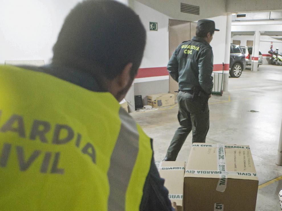 Agentes de la Guardia Civil transportan el material incautado en el registro al Ayuntamiento de Olot (Gerona).