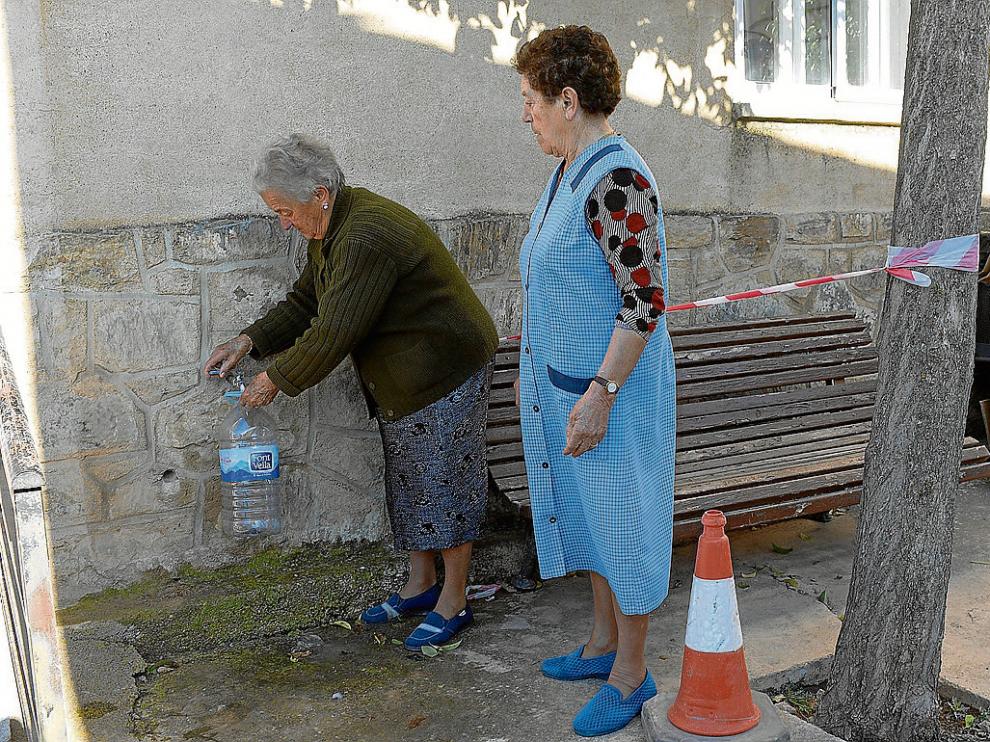 Dos vecinas de Bello llenaban ayer garrafas con agua procedente de la desnitrificadora.