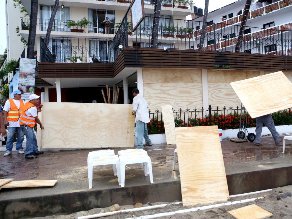 Habitantes de la zona turística de Puerto Vallarta en el estado de Jalisco protegen sus casas y comercios.