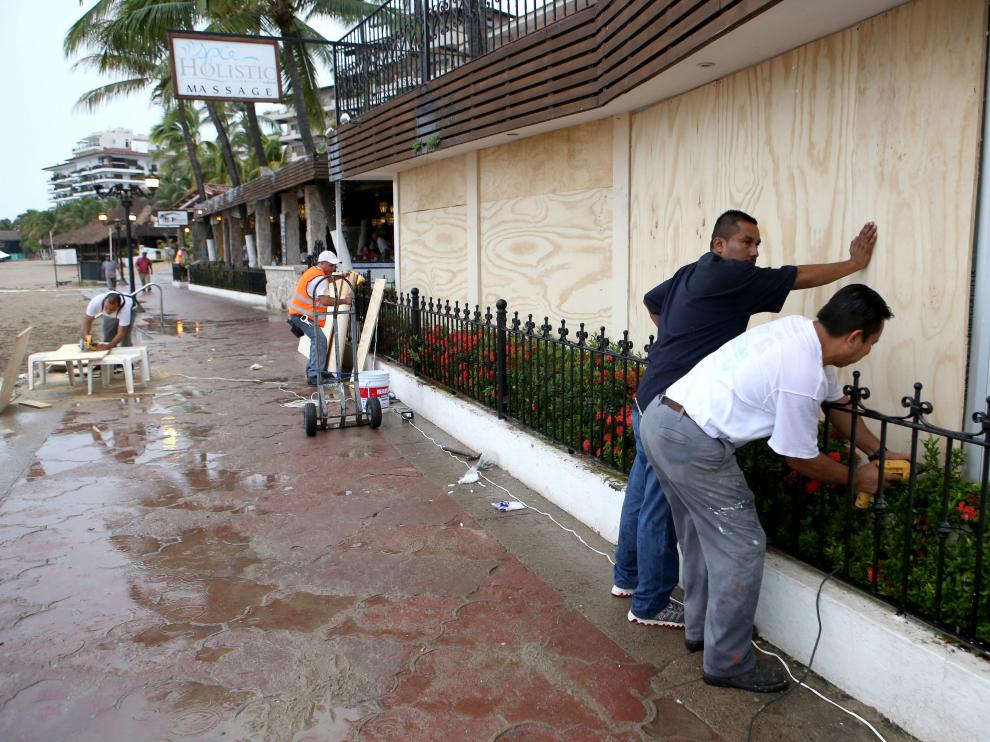 abitantes de la zona turística de Puerto Vallarta en el estado de Jalisco protegen sus casas y comercios.