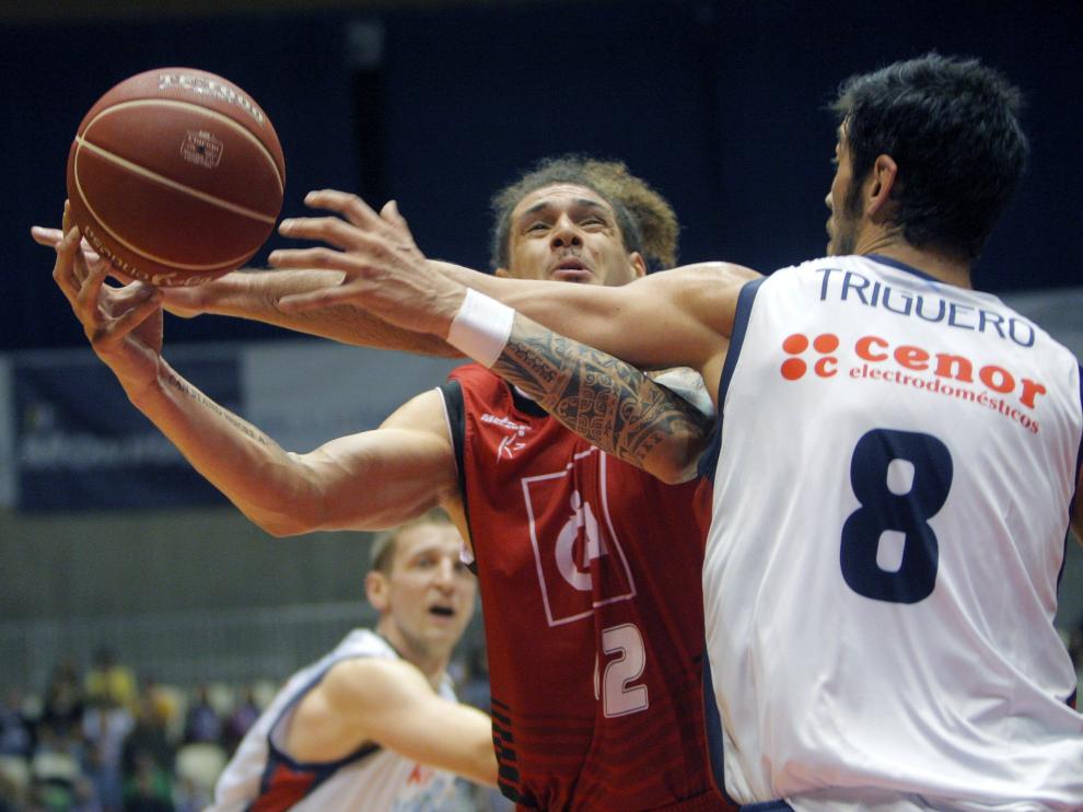 El alero neozelandés del Cai Zaragoza, Isaac Fotu (i), intenta entrar a canasta ante el pivot del Monbus Obradoiro, Juan Triguero, durante el encuentro.