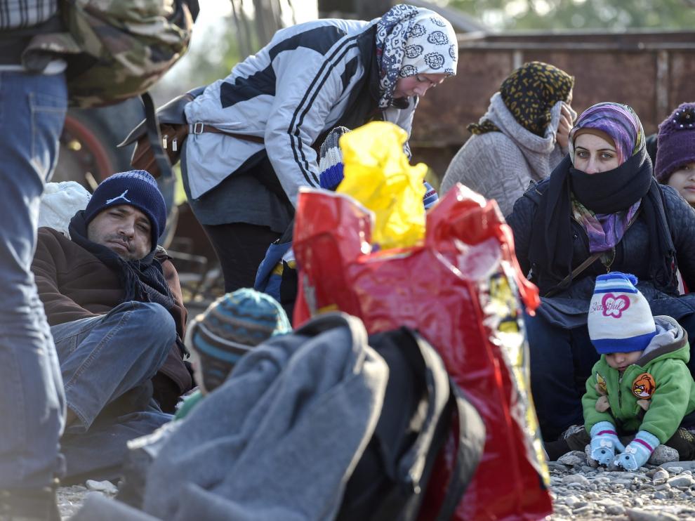 Refugiados esperan obtener permiso para entrar en el centro de registro tras cruzar la frontera entre Grecia y Macedonia.